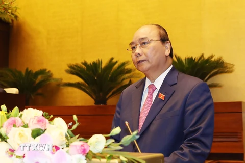 Thủ tướng Nguyễn Xuân Phúc đọc báo cáo của Chính phủ. (Ảnh: Trọng Đức/TTXVN)