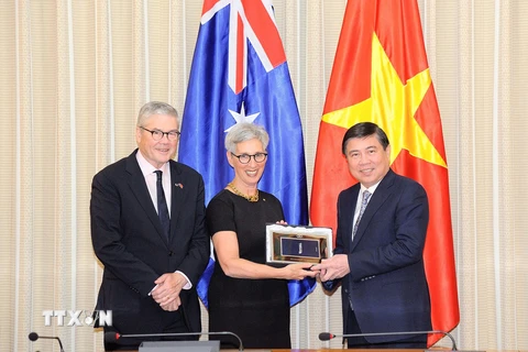 Ông Nguyễn Thành Phong, Chủ tịch Ủy ban Nhân dân Thành phố Hồ Chí Minh (bên phải) tặng quà cho bà Linda Dessau, Thống đốc Bang Victoria, Australia (giữa), ngày 4/10, trong chuyến thăm Thành phố Hồ Chí Minh. (Ảnh: Xuân Khu/TTXVN)