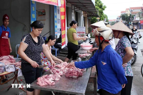 Người dân mua thịt lợn bán tại chợ thuộc huyện Khoái Châu, Hưng Yên. (Ảnh: Phạm Kiên/TTXVN)