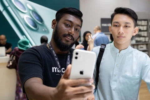 Nhân viên Apple ở Kuala Lumpur giới thiệu cho khách hàng về mẫu điện thoại iPhone 11. (Nguồn: Getty Images)