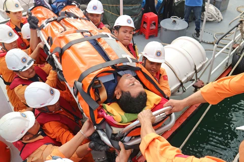 Thuyền viên Syaiful Chandra được đội cứu nạn đưa lên bờ để chuyển đến bệnh viện tiếp tục điều trị. (Ảnh: Nguyễn Dũng/TTXVN)