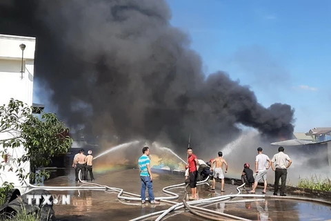Lực lượng chữa cháy nỗ lực không chế ngọn lửa tại hiện trường. (Ảnh: Nguyễn Văn Việt/TTXVN)
