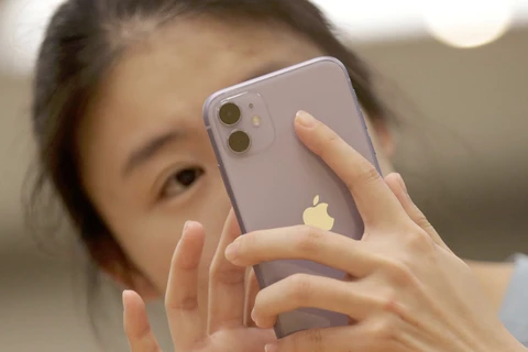 Một người tiêu dùng Trung Quốc sử dụng iPhone 11. (Nguồn: Reuters)
