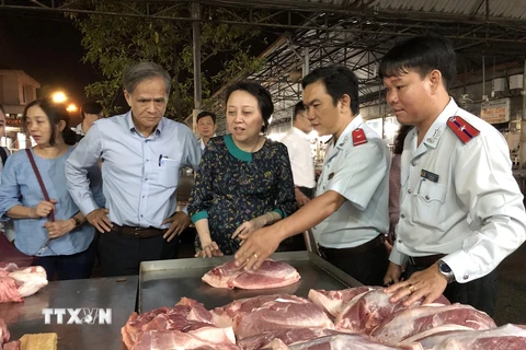 Ban Quản lý an toàn thực phẩm Thành phố Hồ Chí Minh kiểm tra các quầy hàng thịt lợn tại Chợ đầu mối Hóc Môn. (Ảnh: Đinh Hằng/TTXVN)