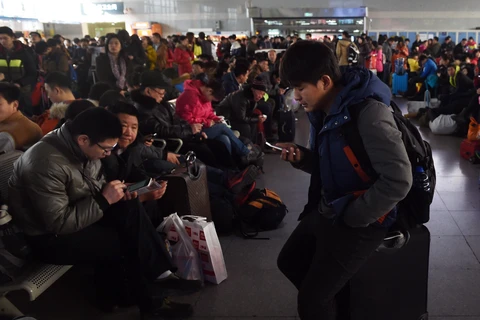 Hành khách chờ tàu về quê đón Tết Nguyên đán tại nhà ga ở Bắc Kinh, Trung Quốc. (Nguồn: AFP/ TTXVN)