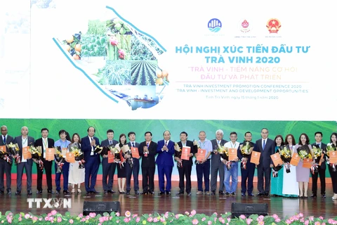 Thủ tướng Nguyễn Xuân Phúc chứng kiến các doanh nghiệp nhận quyết định chủ trương đầu tư, ghi nhớ đầu tư vào tỉnh Trà Vinh. (Ảnh: Thống Nhất/TTXVN)