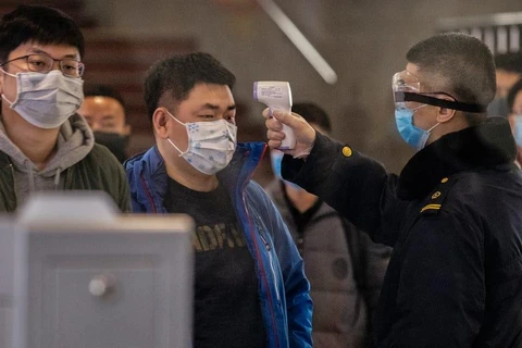 Kiểm tra thân nhiệt hành khách trên tuyến tàu từ Vũ Hán đến Bắc Kinh. (Nguồn: Getty Images)