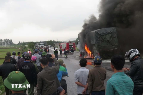 Cảnh sát phòng cháy nỗ lực dập tắt xe ôtô bị cháy trên đường tránh thành phố Vinh đoạn qua xã Nghi Diên, huyện Nghi Lộc, Nghệ An. (Ảnh: Nguyễn Văn Nhật/TTXVN)