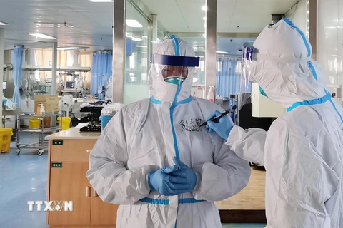 Nhân viên y tế viết tên lên áo tại khoa cách ly điều trị cho bệnh nhân nhiễm virus corona của bệnh viện Zhongnan ở Vũ Hán, tỉnh Hồ Bắc, Trung Quốc, ngày 5/2/2020. (Nguồn: THX/TTXVN)