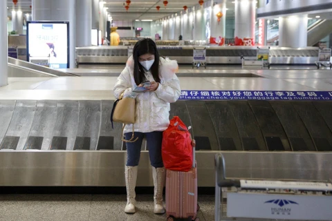 Một phụ nữ sử dụng điện thoại di động ở sân bay tỉnh Hồ Nam, Trung Quốc. (Nguồn: Reuters)