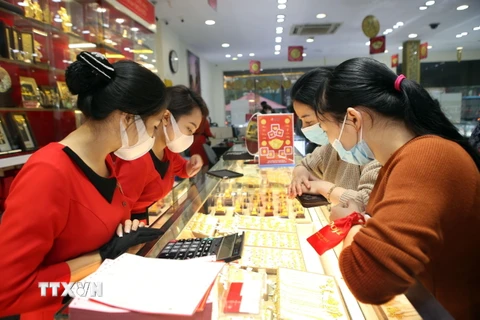 Người dân và nhân viên đều đeo khẩu trang trong khi giao dịch tại Trung tâm vàng bạc trang sức DOJI (Hà Nội). (Ảnh: Danh Lam/TTXVN)