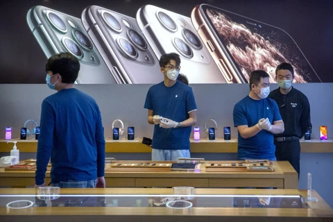 Nhân viên đeo khẩu trang trong một cửa hàng của Apple ở Bắc Kinh. (Nguồn: AP)