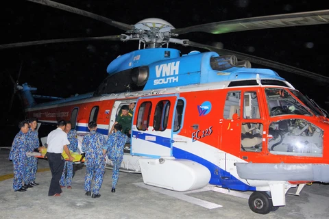 Bệnh nhân được vận chuyển lên trực thăng đưa về đất liền cấp cứu. (Nguồn: TTXVN phát)