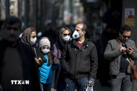 Người dân đeo khẩu trang để phòng tránh lây nhiễm COVID-19 tại Tehran, Iran, ngày 23/2/2020. (Nguồn: THX/ TTXVN)