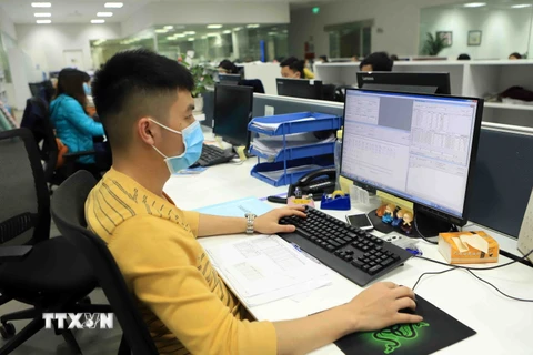 Nhân viên văn phòng Công ty trách nhiệm hữu hạn sản xuất hàng may mặc Việt Nam tại Khu công nghiệp Bá Thiện 2 đeo khẩu trang khi làm việc. (Ảnh: Hoàng Hùng/TTXVN)