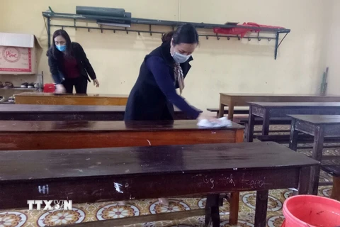 Giáo viên trường trung học cơ sở Dân tộc Nội trú huyện Cẩm Thủy, Thanh Hóa vệ sinh trường lớp chuẩn bị đón học sinh trở lại lớp. (Ảnh: Hoa Mai/TTXVN) 