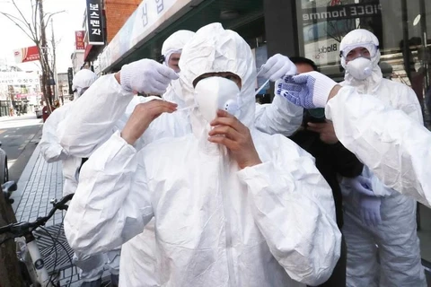 Nhân viên y tế mặc quần áo bảo hộ tại khu vực nguy cơ lây nhiễm cao COVID-19 ở Hàn Quốc. (Nguồn: AP)