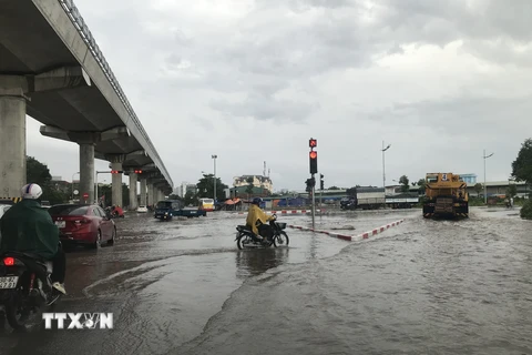 Đoạn đường 32 qua Đại học Công nghiệp Hà Nội (Bắc Từ Liêm) bị ngập khoảng 30cm, phương tiện qua lại khó khăn sau trận mưa to chiều 3/3. (Ảnh: Mạnh Khánh/TTXVN)