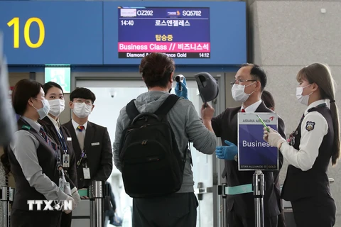 Hành khách trở về Mỹ được kiểm tra thân nhiệt nhằm ngăn chặn sự lây lan của dịch COVID-19 tại sân bay quốc tế Incheon, Hàn Quốc ngày 3/3/2020. (Nguồn: YONHAP/TTXVN)