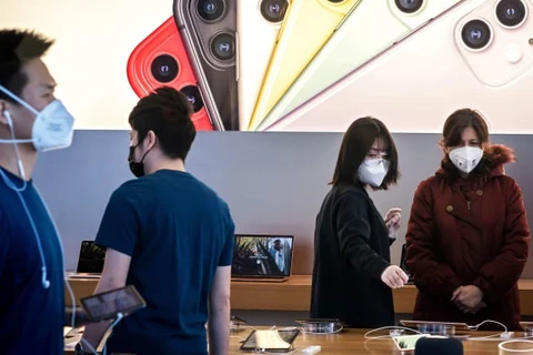 Nhân viên và khách hàng đeo khẩu trang trong một cửa hàng bán lẻ của Apple ở Bắc Kinh. (Nguồn: Getty Images)