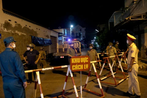 Lực lượng công an thành phố Phan Thiết triển khai cách ly 2 tuyến đường để phòng chống dịch COVID-19. (Ảnh: Nguyễn Thanh/TTXVN)