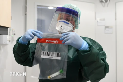 Nhân viên y tế lấy mẫu bệnh phẩm của bệnh nhân nhiễm dịch COVID-19 tại bệnh viện Trường đại học Uniklinikum Essen ở Essen, miền Tây Đức ngày 9/3/2020. (Nguồn: AFP/TTXVN)