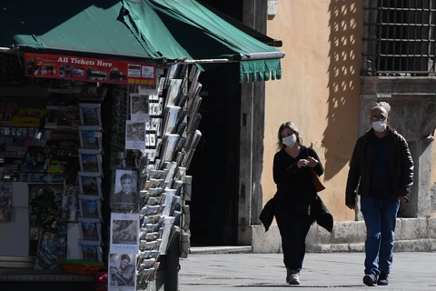 Người dân đeo khẩu trang để phòng tránh lây nhiễm COVID-19 tại Rome, Italy, ngày 12/3/2020. (Nguồn: THX/ TTXVN)