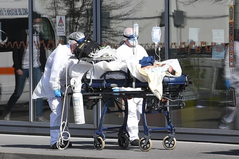Nhân viên y tế chuyển bệnh nhân nhiễm COVID-19 tới bệnh viện ở Strasbourg, Pháp, ngày 16/3/2020. (Nguồn: AFP/TTXVN)