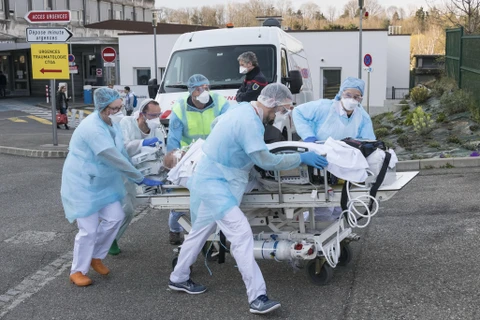Nhân viên y tế chuyển bệnh nhân nhiễm COVID-19 tại Mulhouse, Pháp, ngày 17/3/2020. (Nguồn: AFP/TTXVN)