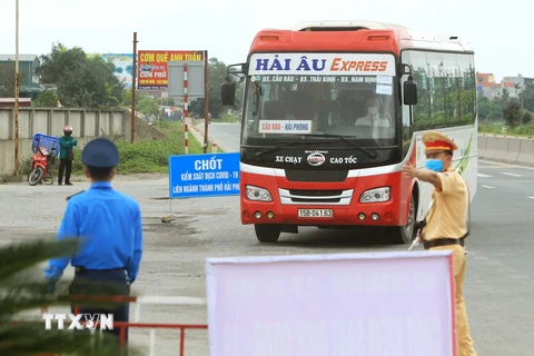 Các lực lượng liên ngành hướng các phương tiện giao thông vào Chốt kiểm kiểm soát dịch bệnh tại chốt huyện Vĩnh Bảo trước khi vào thành phố Hải Phòng. (Ảnh: An Đăng/TTXVN)