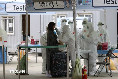 Nhân viên y tế lấy mẫu bệnh phẩm xét nghiệm COVID-19 đối với hành khách đến từ châu Âu tại sân bay quốc tế Incheon, phía tây thủ đô Seoul, Hàn Quốc, ngày 26/3/2020. (Nguồn: Yonhap/ TTXVN)