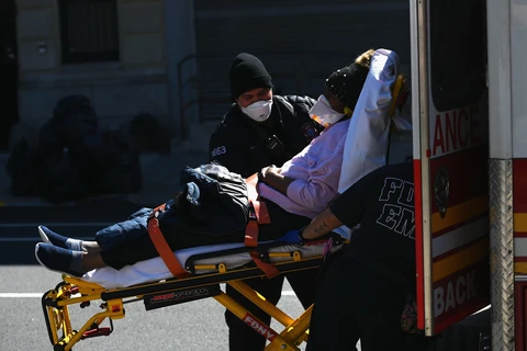 Chuyển bệnh nhân nhiễm COVID-19 từ xe cứu thương vào bệnh viện Brooklyn ở New York, Mỹ ngày 27/3/2020. (Nguồn: AFP/TTXVN)