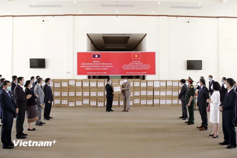 Quang cảnh lễ bàn giao hàng viện trợ của Chính phủ Việt Nam cho Chính phủ Lào để phòng chống dịch COVID-19. (Ảnh: Phạm Kiên/Vietnam+)