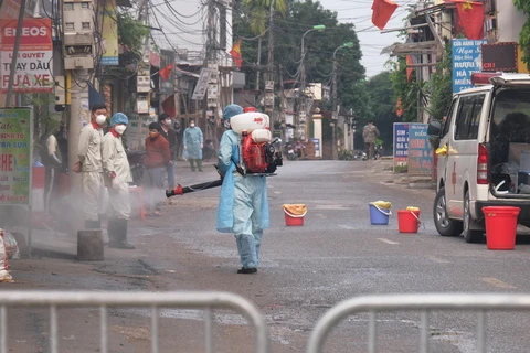 Lực lượng chức năng phun khử khuẩn tại thôn Hạ Lôi (Mê Linh). (Ảnh: Phạm Hùng/TTXVN phát)