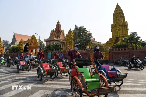 Người dân đeo khẩu trang phòng lây nhiễm COVID-19 trên một đường phố ở Phnom Penh, Campuchia, ngày 30/3/2020. (Nguồn: AFP/TTXVN)