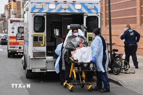 Nhân viên y tế chuyển bệnh nhân nhiễm COVID-19 lên xe cứu thương tới bệnh viện ở New York, Mỹ, ngày 7/4/2020. (Nguồn: AFP/TTXVN)