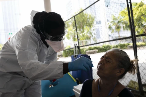 Nhân viên y tế lấy mẫu xét nghiệm COVID-19 cho những người vô gia cư tại Miami, bang Florida, Mỹ, ngày 16/4/2020. (Nguồn: AFP/TTXVN)