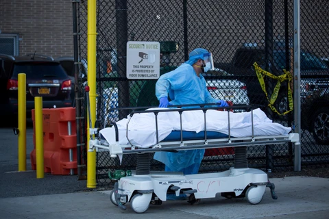 Nhân viên y tế chuyển thi thể bệnh nhân mắc COVID-19 ra nhà xác dã chiến bên ngoài một bệnh viện ở New York, Mỹ ngày 6/4/2020. (Nguồn: THX/TTXVN)
