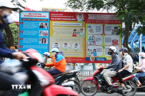 Áp phích tuyên truyền phóng chống COVID-19 trên đường phố Hà Nội. (Ảnh: Lâm Khánh/TTXVN)