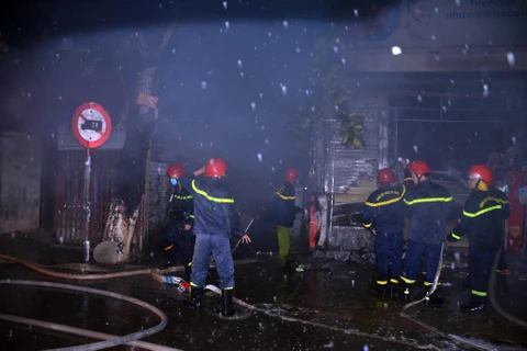 Cán bộ, chiến sỹ Phòng Cảnh sát Phòng cháy chữa cháy và cứu nạn cứu hộ, Công an tỉnh Thừa Thiên-Huế khống chế, dập tắt ngọn lửa trong đêm. (Nguồn: TTXVN phát)