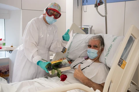 Nhân viên y tế động viên tinh thần bệnh nhân mắc COVID-19 tại một bệnh viện ở Barcelona, Tây Ban Nha ngày 23/4/2020. (Nguồn: THX/TTXVN) 