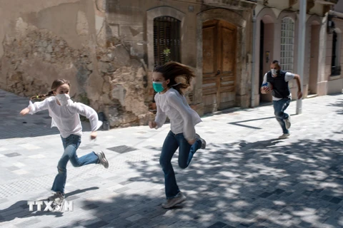 Trẻ em chơi trên đường phố tại Barcelona, Tây Ban Nha trong bối cảnh dịch COVID-19 bùng phát mạnh, ngày 26/4/2020. (Nguồn: AFP/TTXVN)