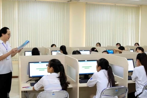Giám thị phổ biến quy chế thi cho thí sinh trước giờ làm bài thi đánh giá năng lực môn Ngoại ngữ trên máy tính tại Đại học Quốc gia Hà Nội. (Ảnh: Quý Trung/TTXVN)
