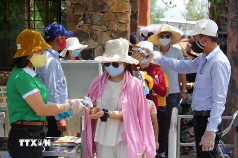 Khách du lịch rửa tay sát khuẩn khi vào tham quan một điểm du lịch ở tỉnh Phú Yên. (Ảnh: Xuân Triệu/TTXVN)
