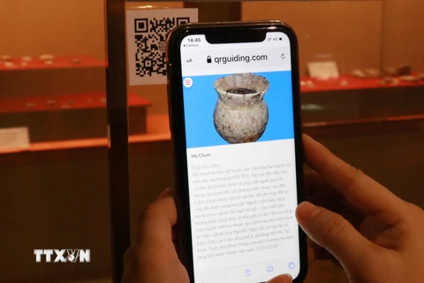 Sử dụng điện thoại thông minh quét mã tem QR code để truy xuất thông tin về hiện vật ở Bảo tàng tỉnh Ninh Thuận. (Ảnh: Nguyễn Thành/TTXVN)