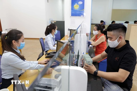Các ngân hàng hỗ trợ người dân và doanh nghiệp bị ảnh hưởng bởi dịch COVID-19. (Ảnh: Trần Việt/TTXVN)
