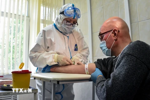 Nhân viên y tế lấy mẫu xét nghiệm COVID-19 cho bệnh nhân tại một cơ sở y tế ở Moskva, Nga ngày 15/5/2020. (Nguồn: AFP/TTXVN)