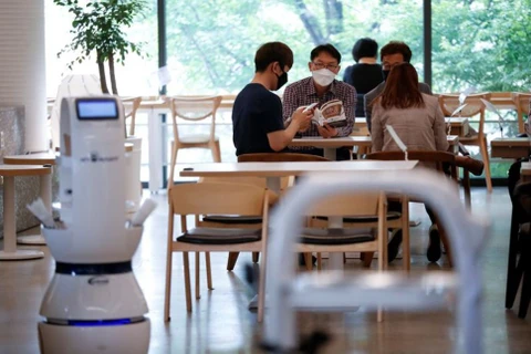 Khách hàng chờ đợi tại quán càphê ở Daejeon khi robot nhận đơn hàng, pha càphê và mang đồ uống đến cho khách hàng. (Nguồn: Reuters)