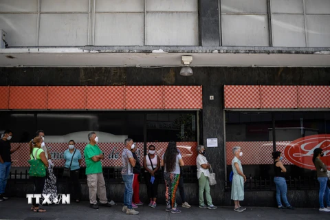 Người dân xếp hàng bên ngoài một siêu thị ở Chacao, vùng lân cận thủ đô Caracas, Venezuela ngày 20/3/2020 trong bối cảnh dịch COVID-19 bùng phát. (Nguồn: AFP/TTXVN)
