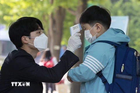 Kiểm tra thân nhiệt cho học sinh tại trường tiểu học ở Seoul, Hàn Quốc ngày 27/5/2020. (Nguồn: THX/TTXVN)